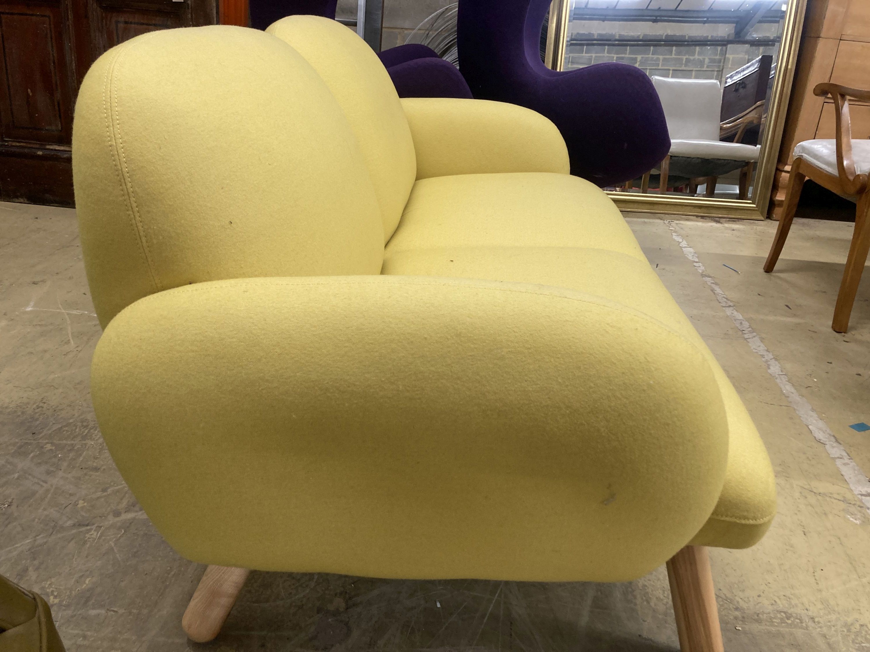 A contemporary pale yellow fabric two seater settee, length 160cm, depth 80cm, height 76cm